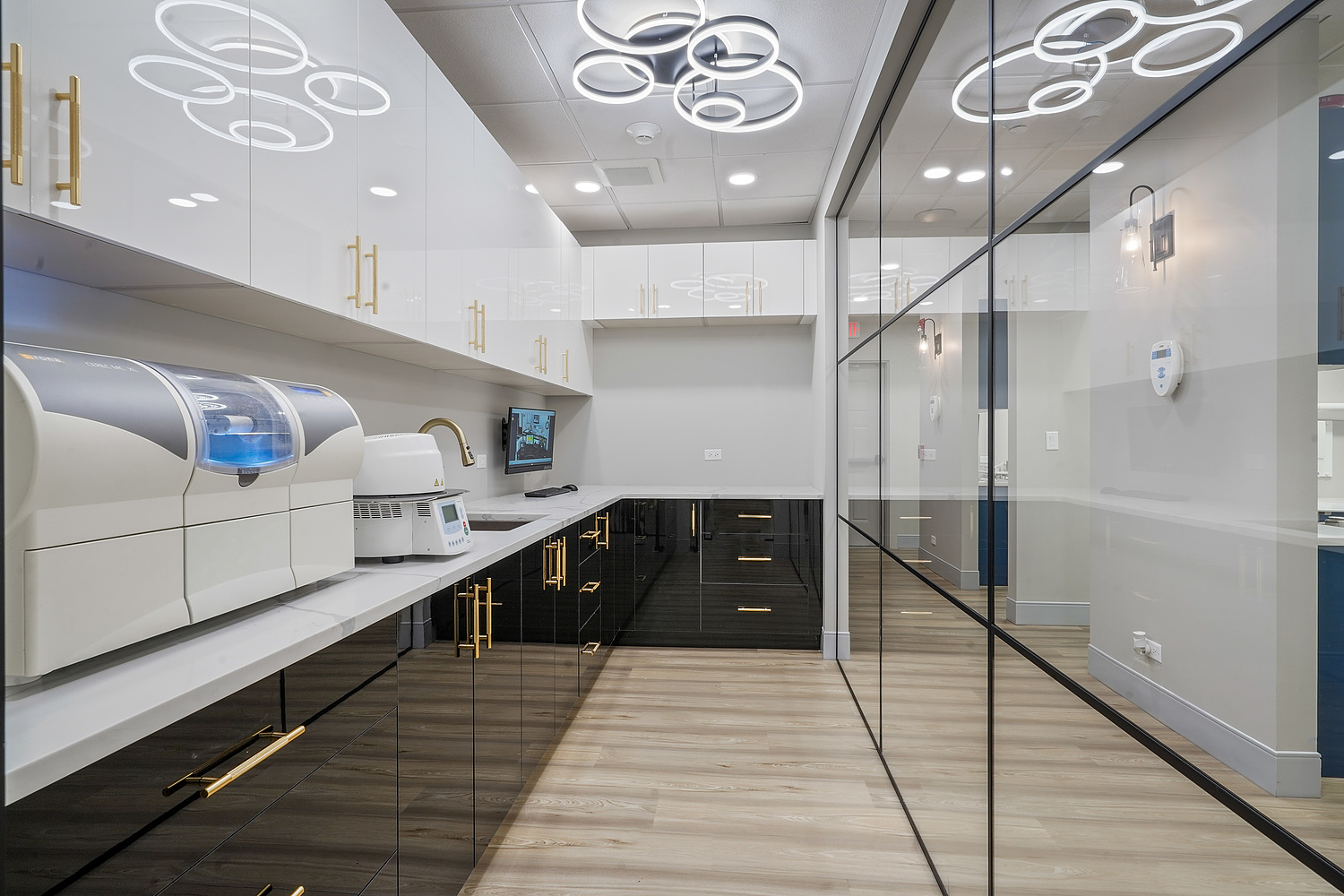 Modern office interior with sleek furniture, reflective surfaces, and a central glass partition.