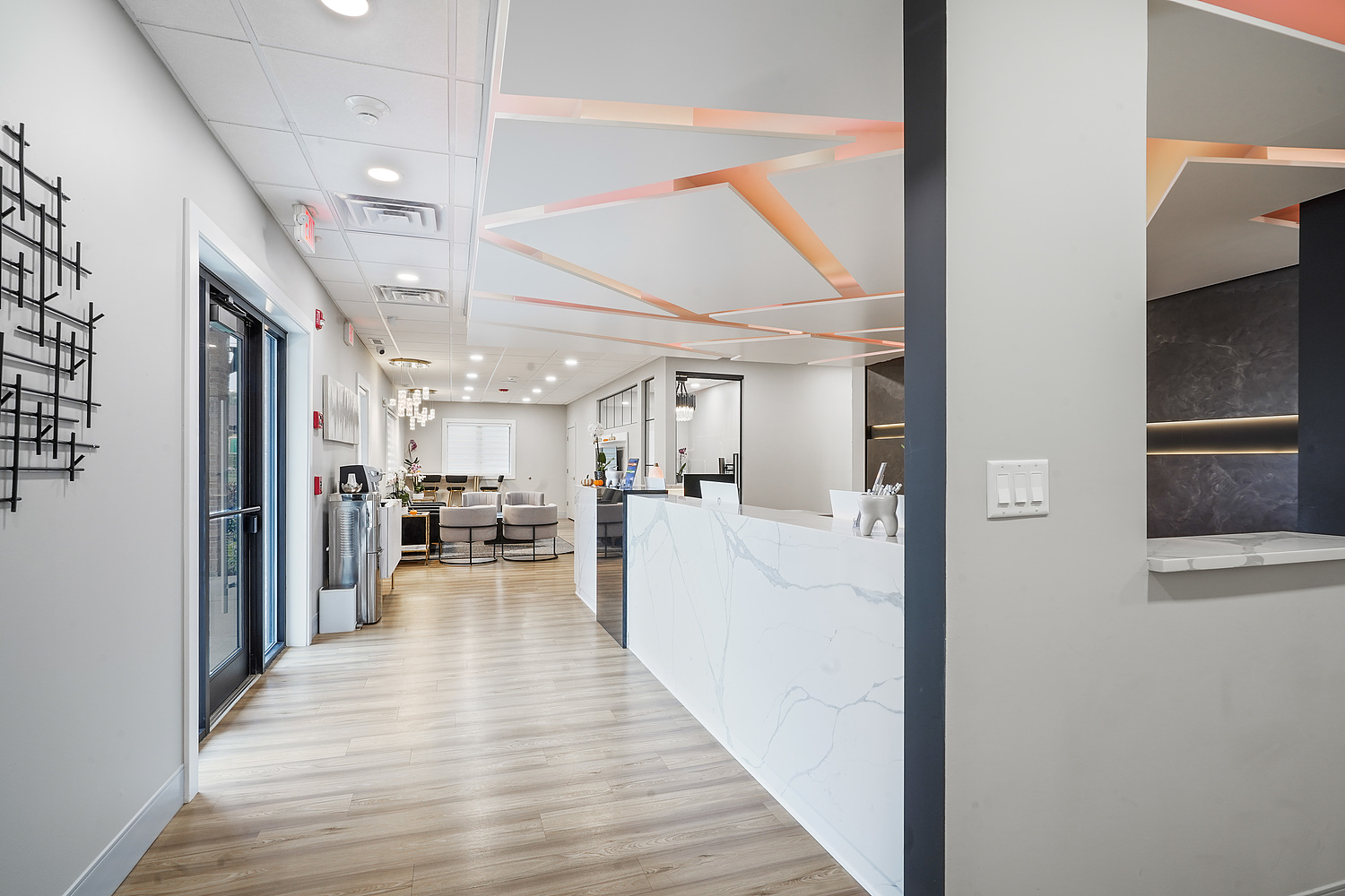 The image shows an interior space that appears to be a modern office or lobby, featuring a clean and contemporary design with sleek furniture, neutral color palette, and decorative elements.