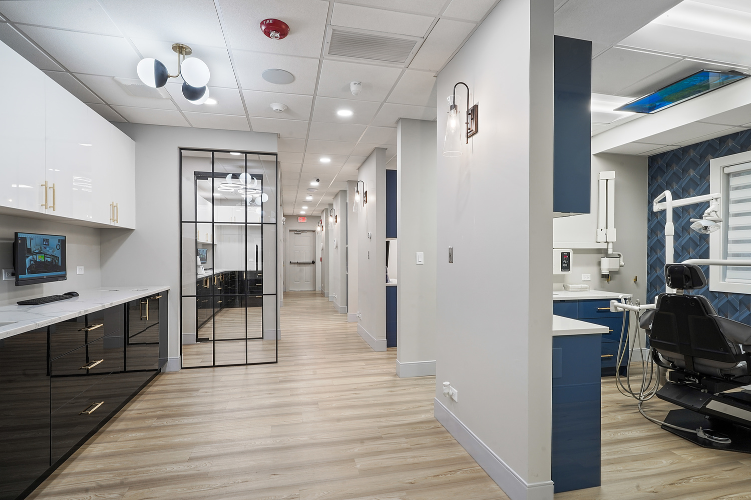 An image of a modern dental office interior with sleek furniture and equipment, featuring a reception area and dental chairs.