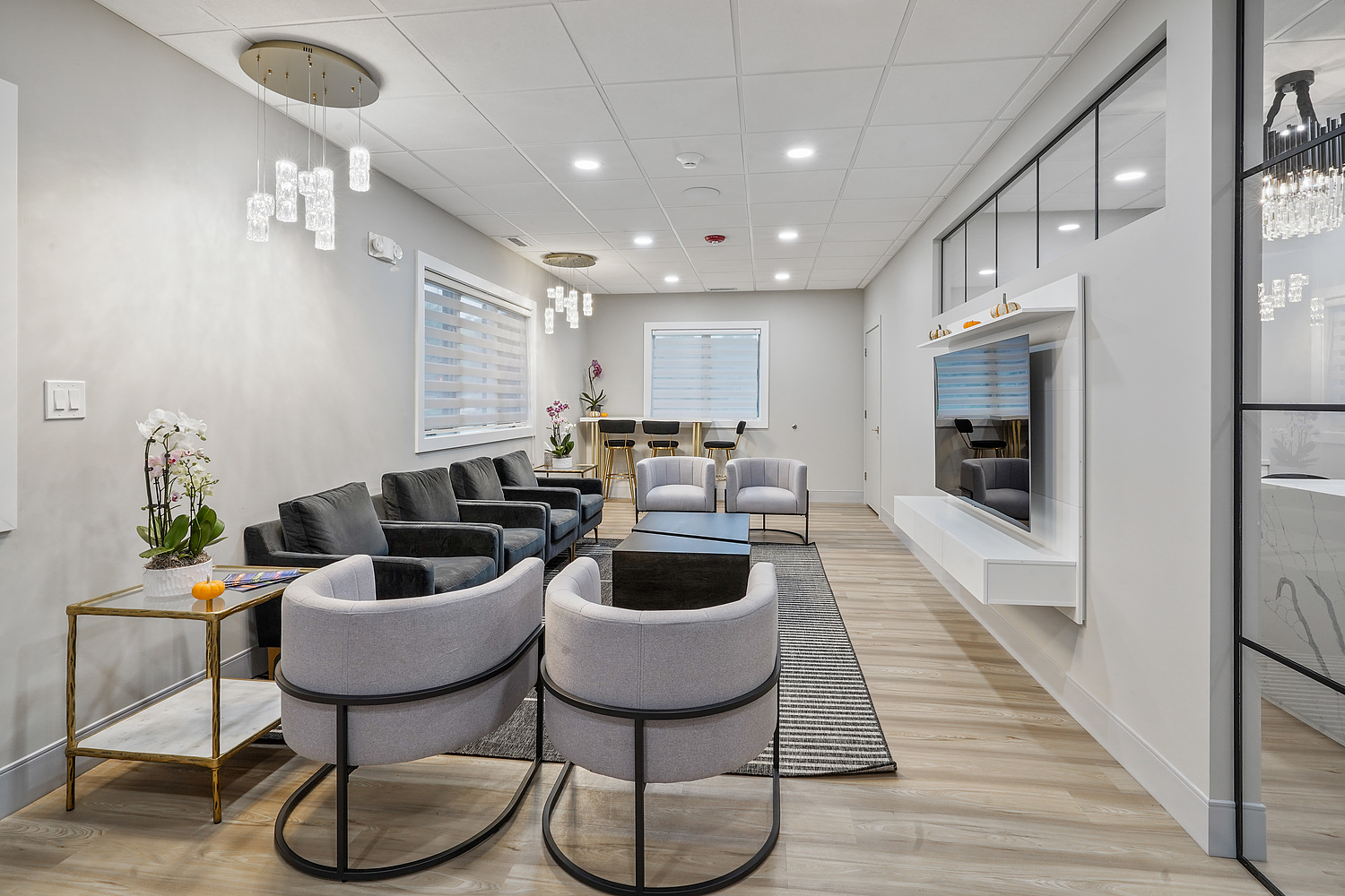 The image shows a modern interior of a waiting room or lobby, featuring contemporary furniture and decor.