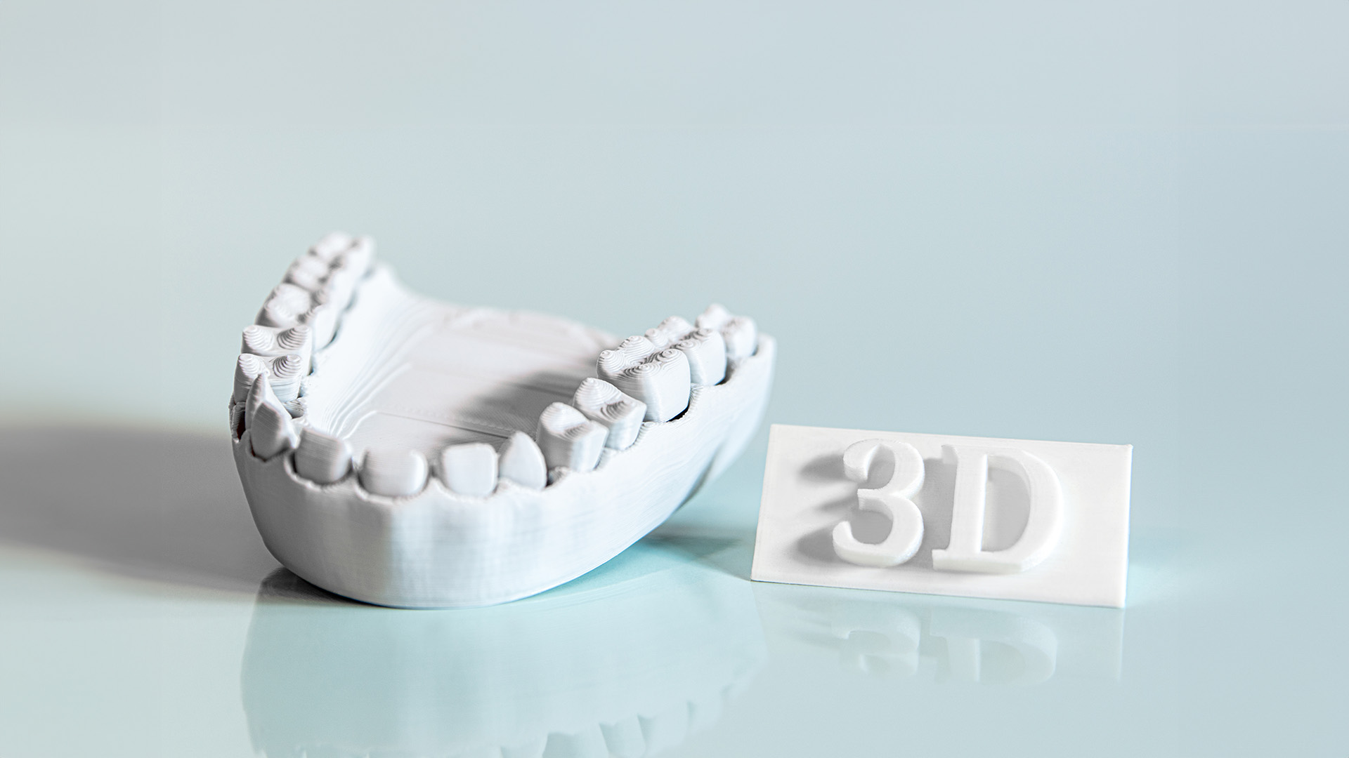 The image shows a 3D printed dental implant and a corresponding 3D printing template on a light background.