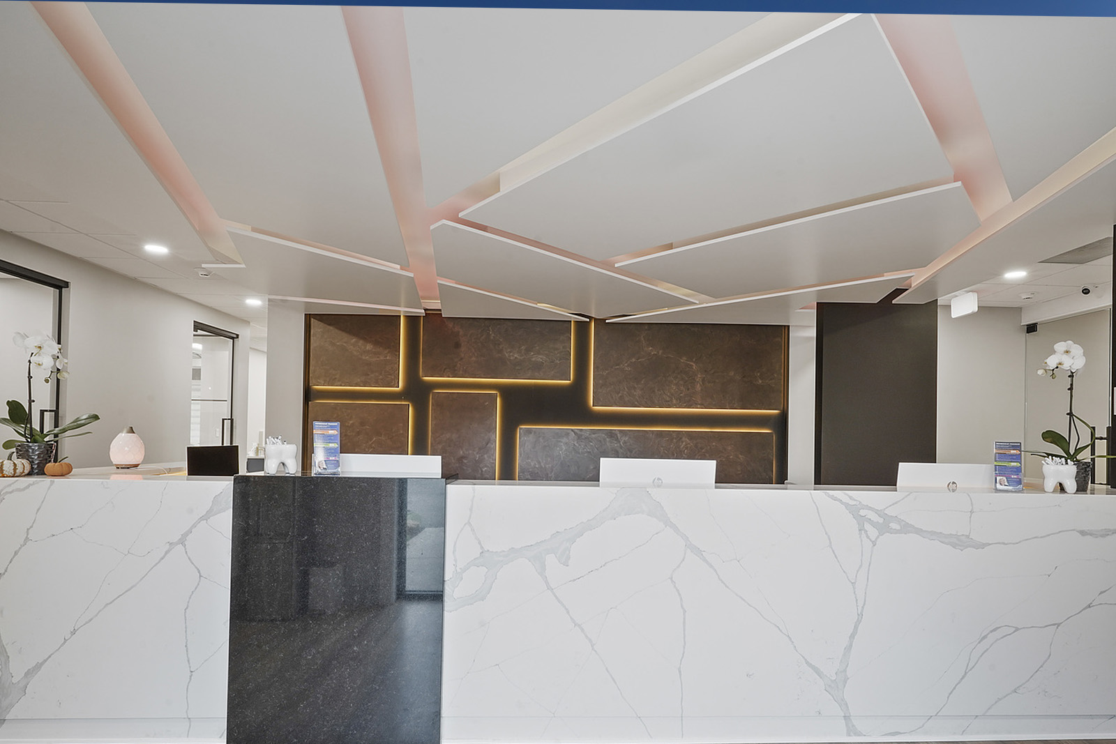 An interior view of a modern reception area with a marble countertop, a large abstract wall art, and a contemporary design.