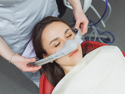 A dental professional fitting a patient with a mouthguard.