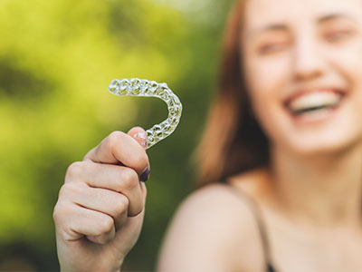 The image shows a person holding up a toothbrush with bristles, which is an inanimate object.