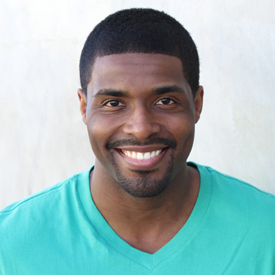 The image shows an older couple, a man and a woman, sitting closely together with smiles on their faces. They appear to be enjoying each other s company in a casual outdoor setting.