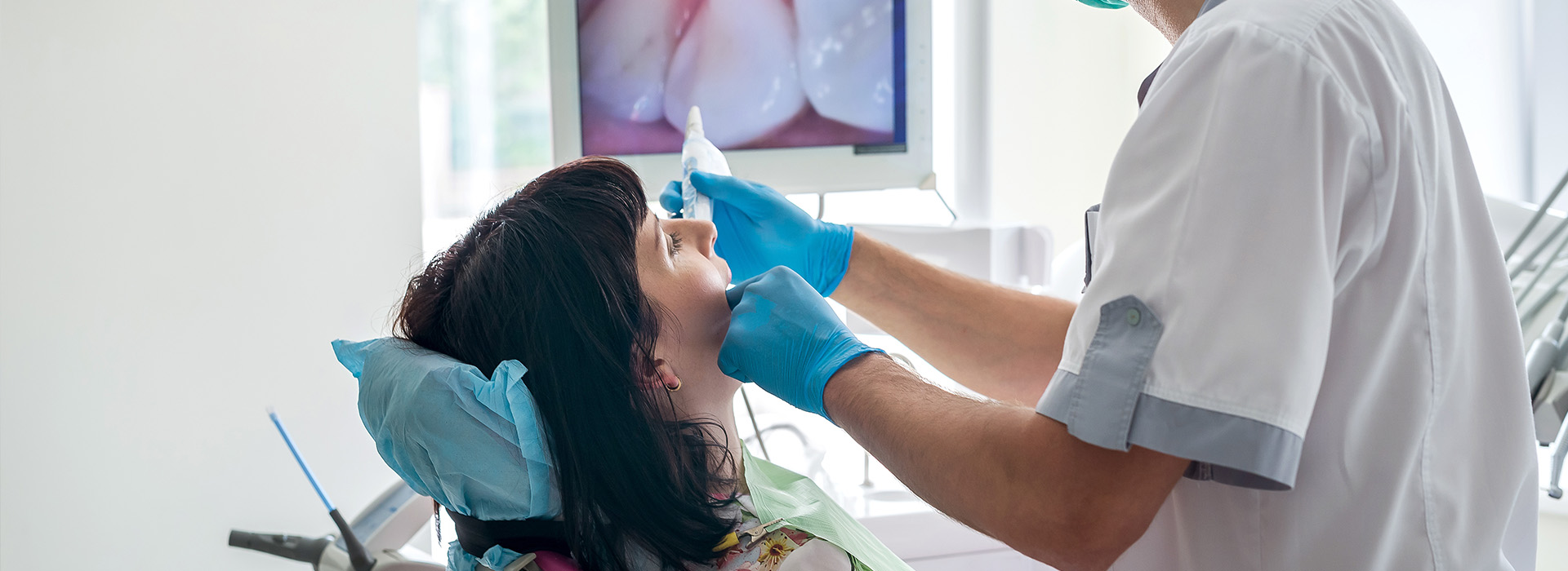 A dental hygienist is performing a teeth cleaning procedure on a patient.