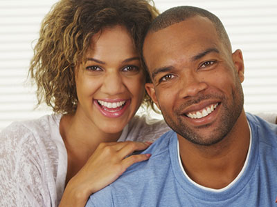 A smiling man and woman posing together for a photo.