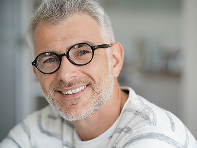 A middle-aged man with glasses, a beard, and mustache, smiling at the camera.