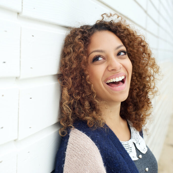Closeup portrait of a beautiful young woman laughing and looking away